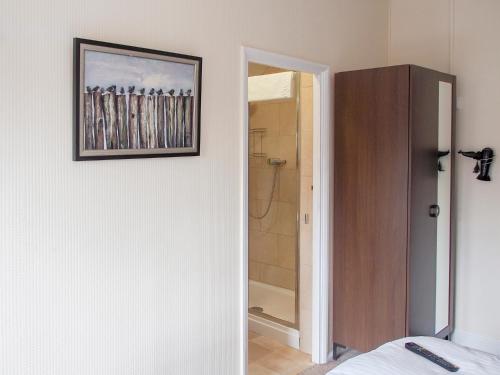 バーミンガムにあるElmdon Lodgeのシャワー付きのベッドルーム1室、壁に絵が描かれています。