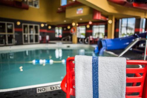 a red and white towel sitting on a chair next to a swimming pool at Comfort Suites in Kelowna