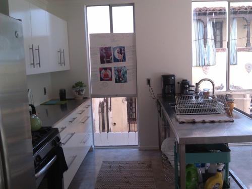 a kitchen with white cabinets and a sink at Ocean Front Vortex Female Hostel private rooms Free bikes in Los Angeles