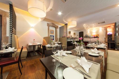 a dining room with tables and chairs in a restaurant at Novina Hotel Tillypark in Nürnberg