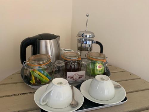 - une table avec une cafetière et des bocaux dans l'établissement Bar 145, à Droux