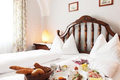 a hotel room with a bed with food on it at Stadthotel Restaurant Auerhahn in Vöcklabruck