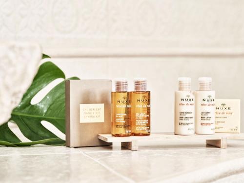 a set of four bottles of essential oils on a shelf at San Antonio - Small Luxury Hotels of the World in Imerovigli