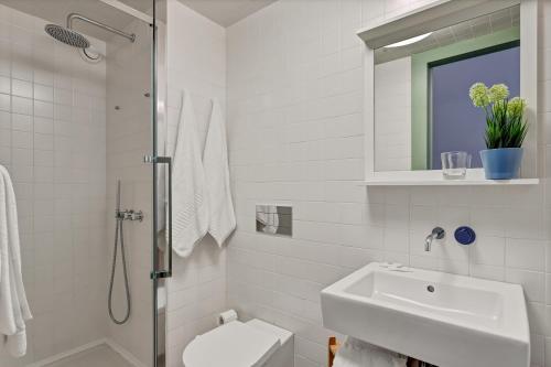 ein weißes Bad mit einem Waschbecken und einer Dusche in der Unterkunft OX Apartments B Arts in Porto
