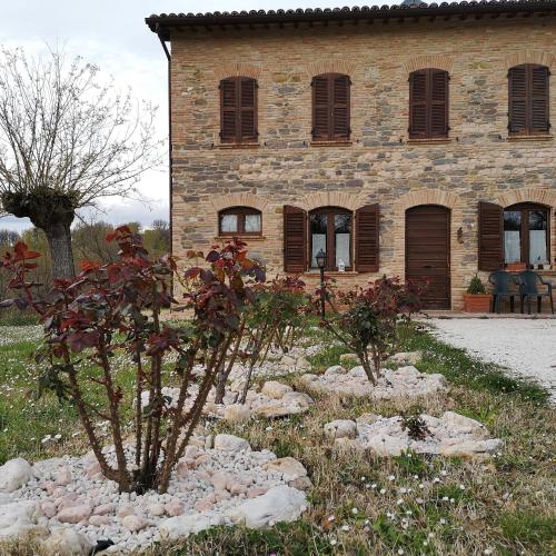 a stone building with a garden in front of it at Da Foschetta in Matelica