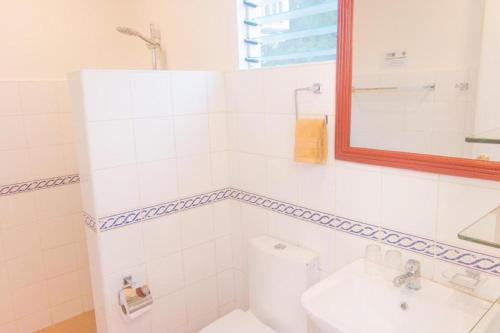 a bathroom with a toilet and a sink and a mirror at Alona Vida Beach Hill Resort in Panglao