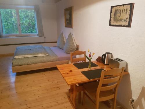 a room with a table and a bed and a dining room at Bio Hof Moosburg am See mit Sauna in Güttingen