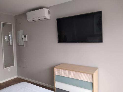 Un dormitorio con un televisor de pantalla plana en la pared. en Apto en Aguadulce con Vistas al Mar, en Aguadulce