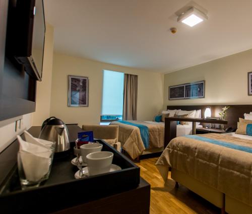 a hotel room with two beds and a tv at Caseros 248 Hotel in Cordoba