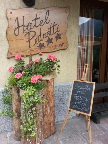 a hotel registration sign on the side of a building at Hotel Pedretti in Branzi