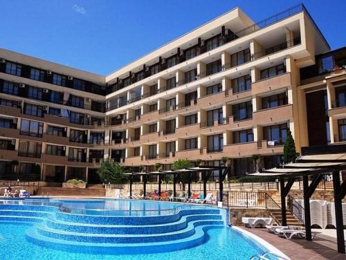 ein Hotel mit einem Pool vor einem Gebäude in der Unterkunft Apartament Luxor Sweti Włas in Sweti Wlas