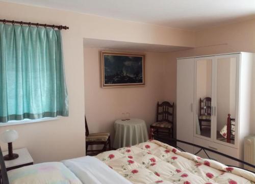 a bedroom with a bed and a table and a window at Guest House Westwood in Kraljevec Kupinečki