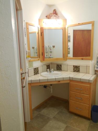 uma casa de banho com um lavatório e 2 espelhos em Yosemite Paradise Inn em Coulterville
