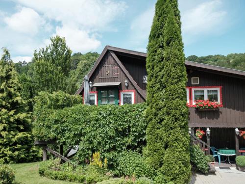 una casa con un gran árbol delante de ella en Quaint Holiday Home in Elbingerode near Forest en Neuwerk