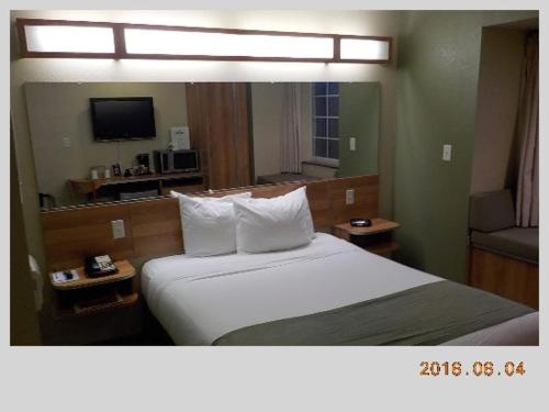 a hotel room with a bed and a television at Microtel Inn & Suites by Wyndham Saraland in Saraland