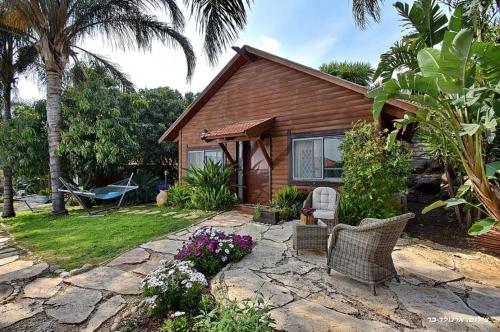 una casa con un patio con sillas y flores en Agama, en Livnim