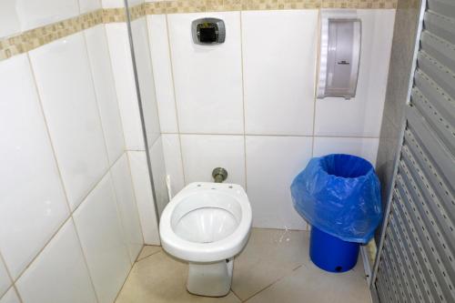a small bathroom with a toilet and a trash can at Vila Suítes Coliving in Vila Velha