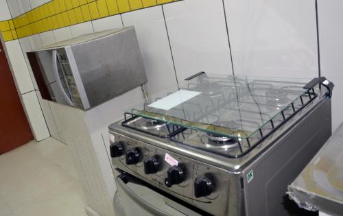 a kitchen with a stove top oven in a kitchen at Vila Suítes Coliving in Vila Velha