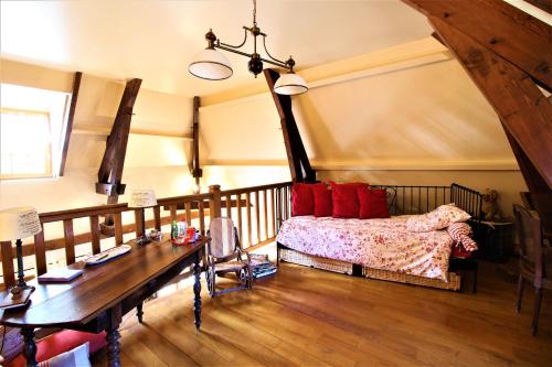 a bedroom with a bed with red pillows and a table at Chez Pascaline in Sarliac-sur-lʼIsle