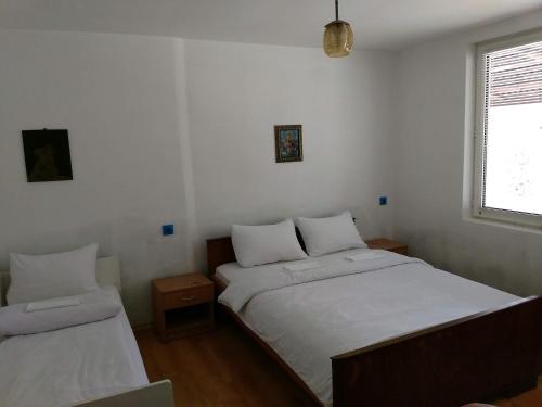 a bedroom with two beds and a window at Bungalows Zdravets in Berkovitsa