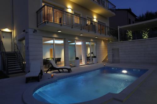 a swimming pool in front of a house at night at Holiday home ''Oasi'' in Pula