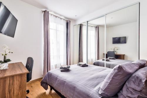 a bedroom with two beds and a large window at The Pearl Suite in Vitry-sur-Seine
