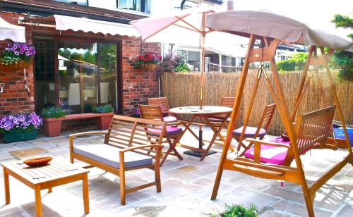 a patio with chairs and a table with an umbrella at Acorn Guest House in Hull in Hull
