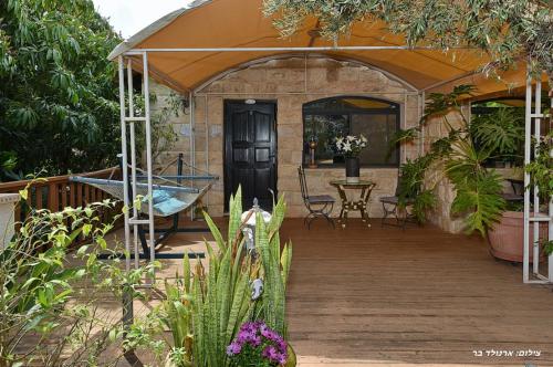 a house with an orange roof and a wooden deck at Agama in Livnim