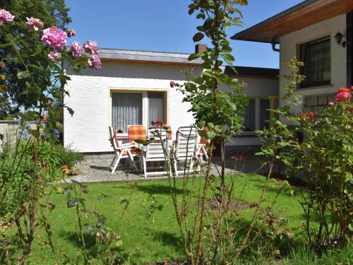 een huis met een tafel en stoelen in de tuin bij Attractive Bungalow in Ilsenburg with Terrace in Ilsenburg