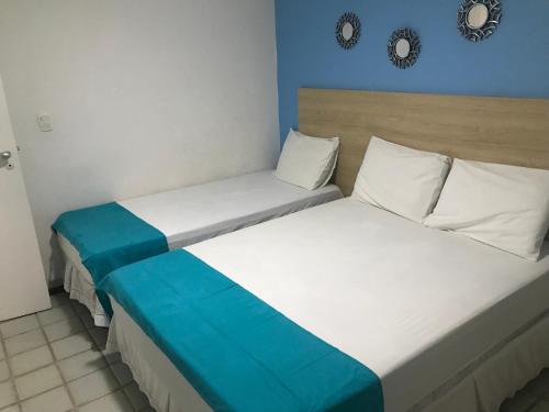 2 Betten in einem blau-weißen Zimmer in der Unterkunft Ancorar Flat Porto de Galinhas - Flat 1203-5205 in Porto De Galinhas