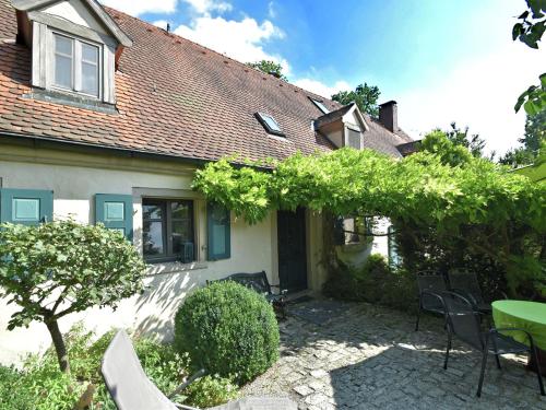 ein Haus mit einer Terrasse, einem Tisch und Stühlen in der Unterkunft Cosy holiday home with gazebo in Weißenburg in Bayern