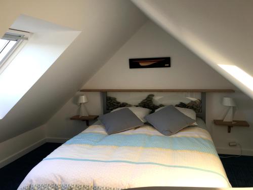 1 dormitorio con 1 cama con 2 almohadas en Kerocéan appartement vue sur mer, en Binic