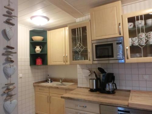 a kitchen with wooden cabinets and a microwave at Villa Harmonie in Lohme