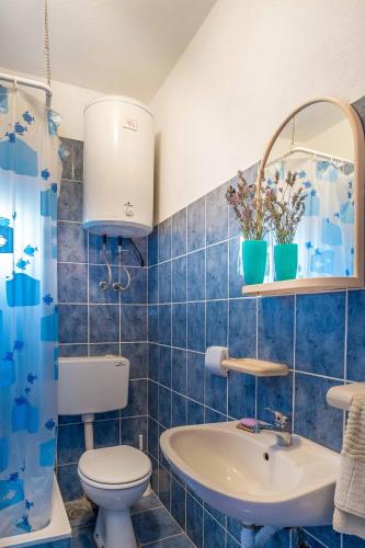 a blue tiled bathroom with a toilet and a sink at Silver Beach Apartments Vis in Vis
