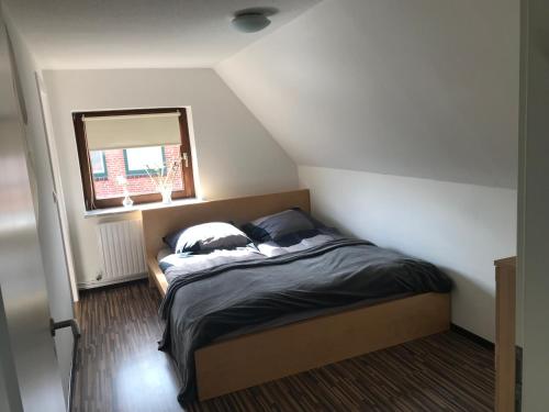 a bedroom with a bed in a room with a window at Ferienhaus im Sandkamp in Westensee