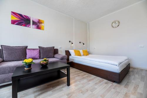 Zimmer mit einem Bett, einem Sofa und einem Tisch in der Unterkunft Compact apartment near Food Market in the Oldtown plus Free parking in Klaipėda