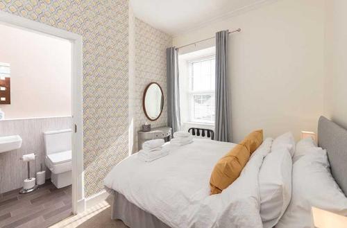 sypialnia z łóżkiem, umywalką i lustrem w obiekcie Maxwelston Farmhouse w mieście Girvan