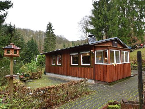 a small wooden cabin in the middle of a garden at Luxurious Bungalow in Neustadt Harz with Private Terrace in Ilfeld