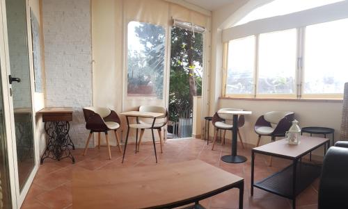 a room with chairs and tables and windows at B&B Casa Derosas in Golfo Aranci