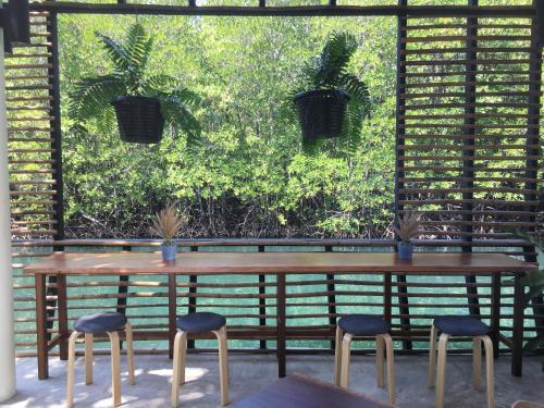 a table and four stools in front of a window at Escape Life Koh Kood in Ko Kood
