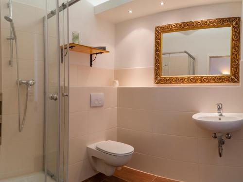 ein Badezimmer mit Toilette, Waschbecken und Spiegel in der Unterkunft Domizil am Kaitzbach in Dresden