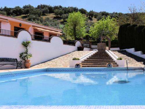 a swimming pool in front of a house with stairs at Belvilla by OYO Casa Mi Pepe in Priego de Córdoba