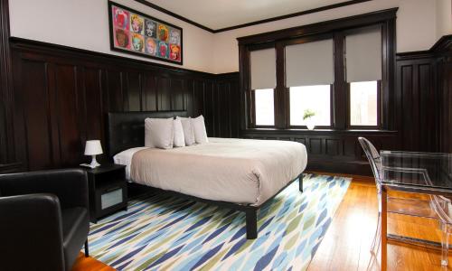 a bedroom with a bed and a chair and windows at A Stylish Stay w/ a Queen Bed, Heated Floors.. #37 in Brookline