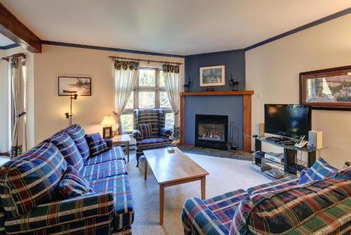 a living room with two couches and a fireplace at Condo Jardins du Village Mont-Tremblant in Mont-Tremblant