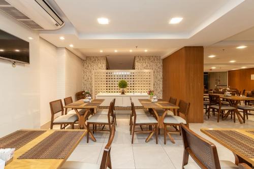 ブルスケにあるTri Hotel Executive Brusqueの木製のテーブルと椅子のあるダイニングルーム