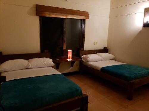 a room with two beds and a candle on a table at Villas Panaca Portal 1 in Quimbaya
