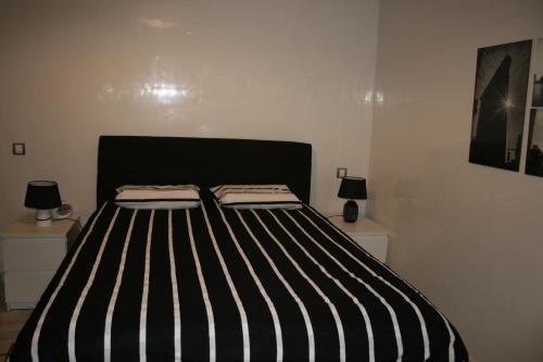 a black and white bed in a room with two lamps at La Siesta Beach Resort in Mohammedia