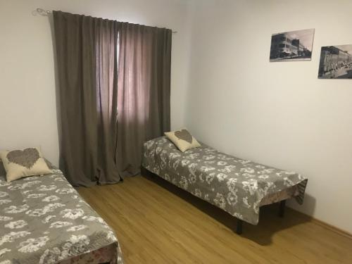 a room with two beds and a window with curtains at Апартаменты в центре города in Mukacheve