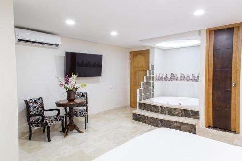 a room with a bed and a table and a tub at Hotel San Pedro del Fuerte in Medellín