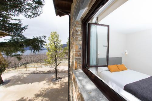 um quarto com uma janela com uma cama e uma vista em Villa Lucerna Sports & Hotel Resort em Vigo de Sanabria